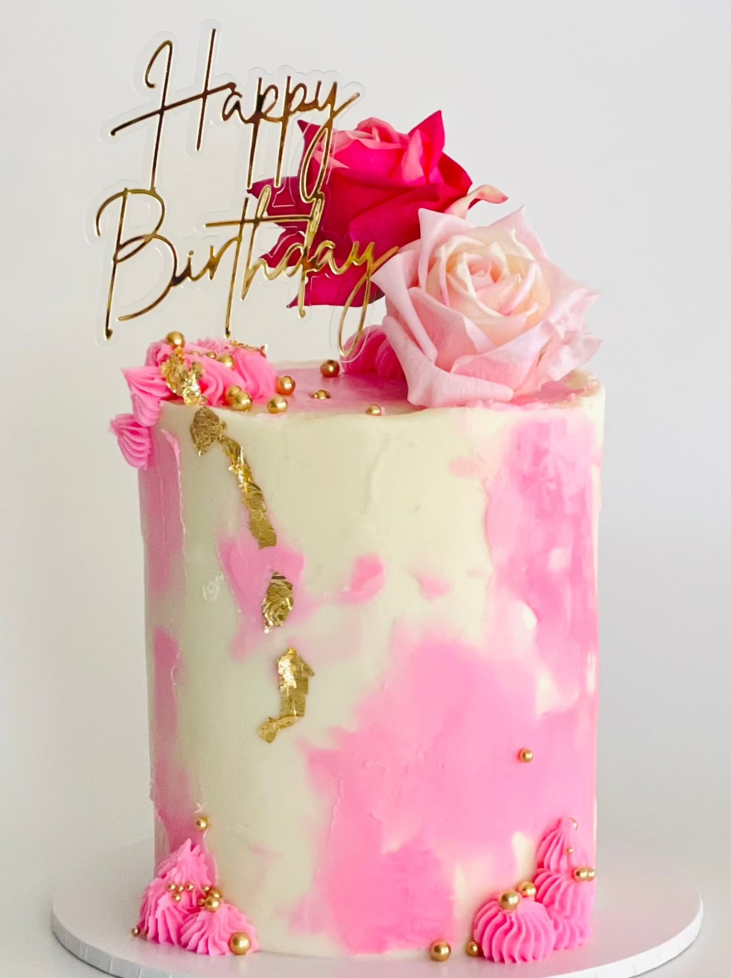 Pretty cake with pink finishes and pink roses perfect for any celebration or a gift