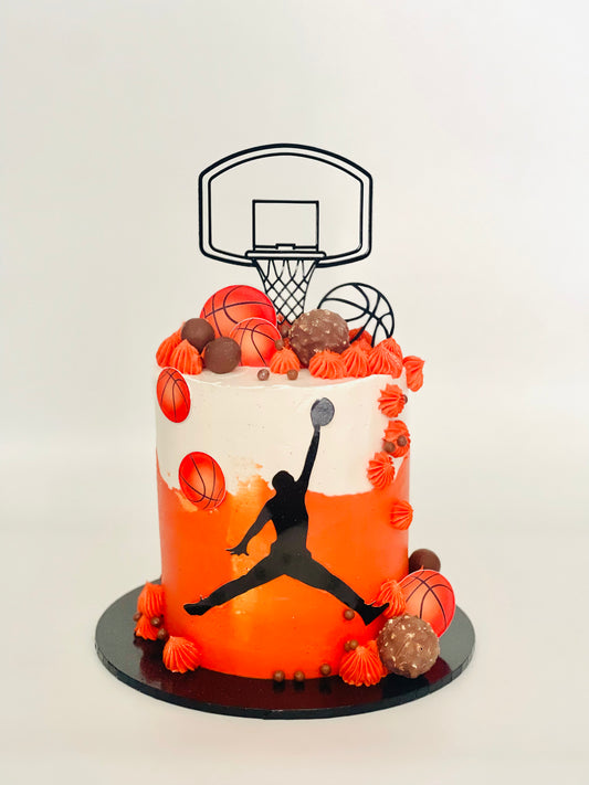 Cake decorated with basketball theme including a silhouette of a player and a hoop.