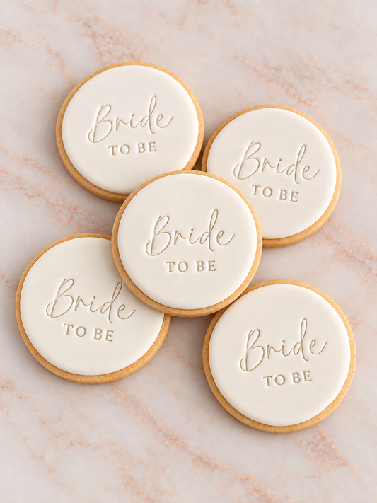 Five round fondant cookies with 'Bride TO BE' stamped in elegant script