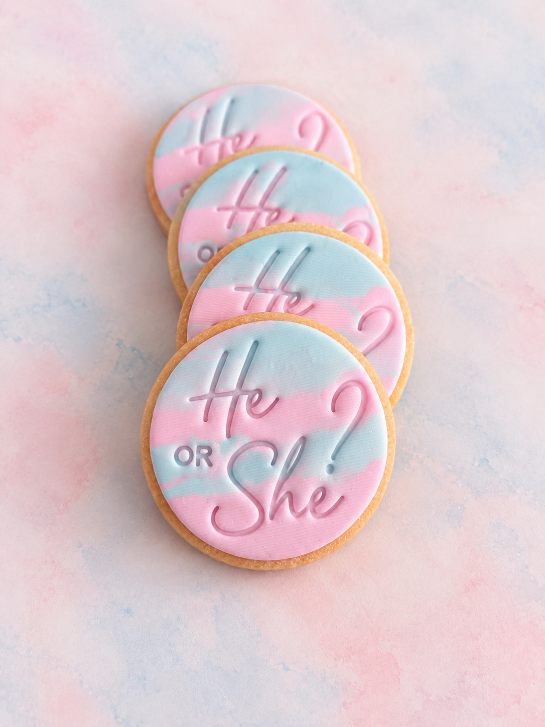 cookie decorated with pink and light blue icing and the words 'He OR She?' stamped