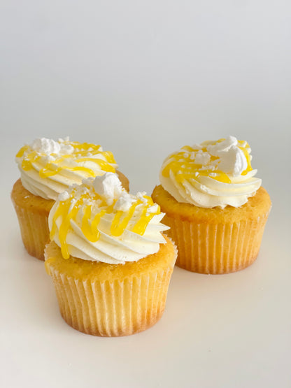 Vanilla cupcakes with lemon filling, white frosting and lemon curd drizzle 