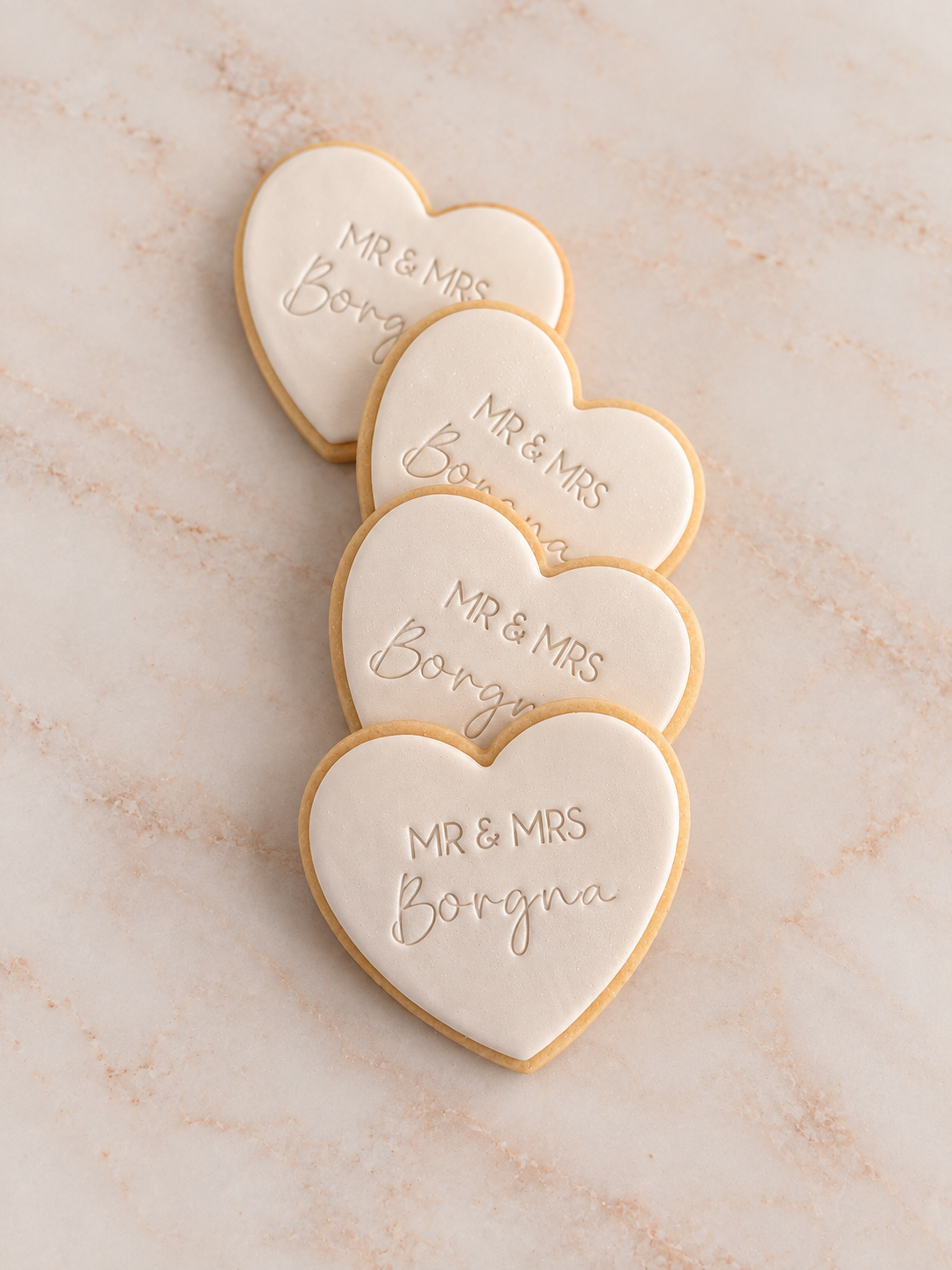 Four heart-shaped sugar cookies with Mr & Mrs and personalized names