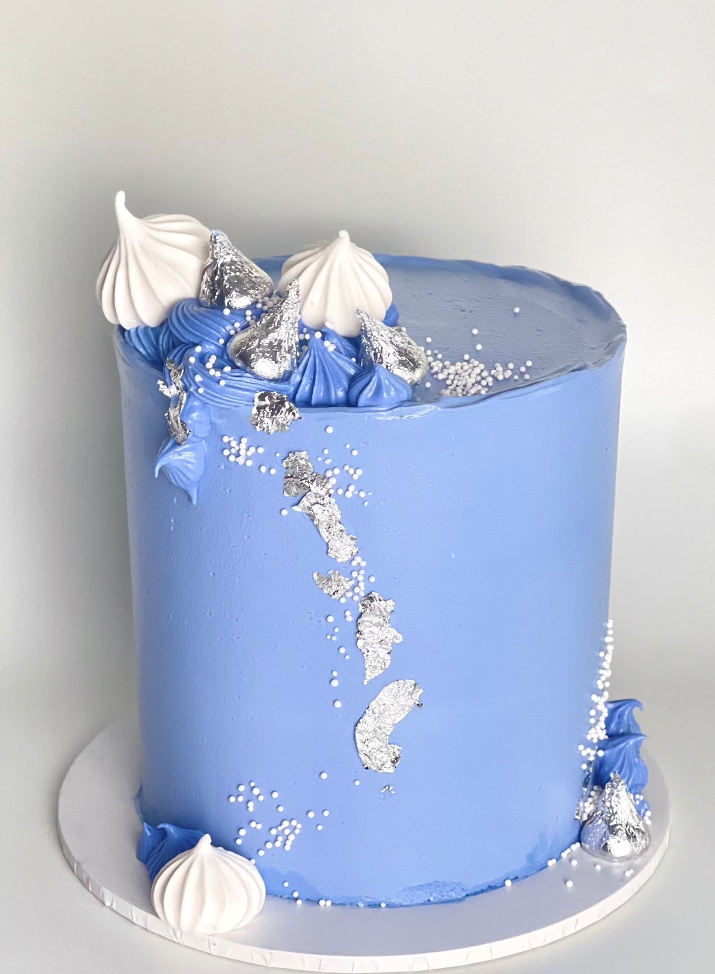 Elegant royal blue cake with silver adornments, complemented by Kisses chocolate and meringues, available for delivery in Brisbane