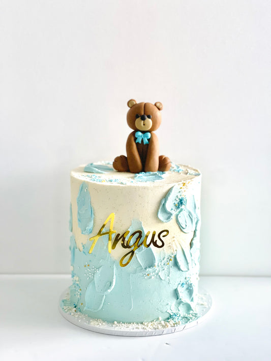 pretty cake with a edible teddybear on top perfect for first birthday or baby shower